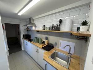 a kitchen with a sink and a counter at Coastal Comfort, Hot Tub Lodge in Margate