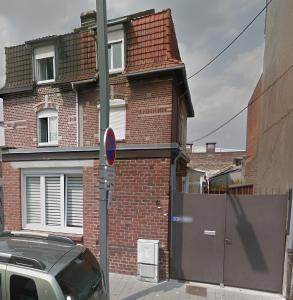 a car parked in front of a brick building at La brique rouge - Maison 66 m2 avec 2 chambres in Lille