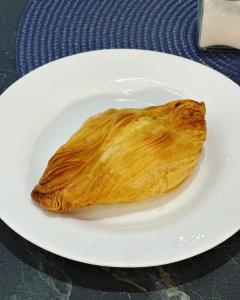 a puff pastry on a white plate on a table at The Central guesthouse in Tal-Pietà