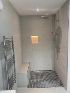 y baño con ducha y suelo de baldosa. en Kells Bay Apartment en Kells