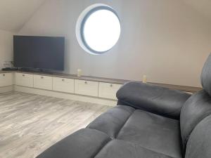 ein Wohnzimmer mit einem Sofa und einem Flachbild-TV in der Unterkunft Kells Bay Apartment in Kells
