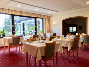 a dining room with white tables and chairs at Landhotel Hubertus in Unterelsbach