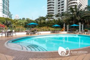 a large swimming pool with chairs and umbrellas at UBN by Plush in Kuala Lumpur