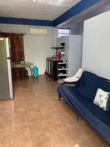ein Wohnzimmer mit einem blauen Sofa und einem Tisch in der Unterkunft Celi’s Ocean Apartment in Caye Caulker
