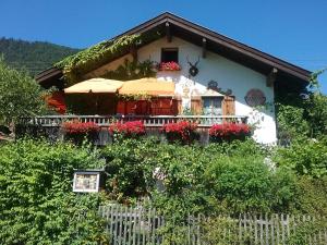 a house with flowers in front of a fence at Landhaus Lucia 2 in Oberau