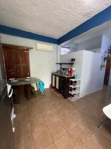 a small kitchen with a table and a refrigerator at Celi’s Ocean Apartment in Caye Caulker