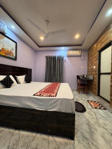 una camera con un grande letto e una scrivania di HOTEL AARNA a Tezpur