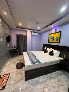ein Schlafzimmer mit einem großen Bett und einem Schreibtisch in der Unterkunft HOTEL AARNA in Tezpur