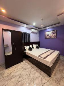 a bedroom with a bed and a purple wall at HOTEL AARNA in Tezpur