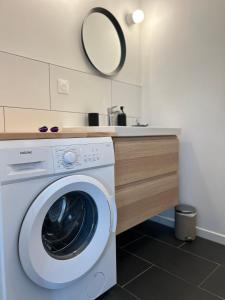 a washing machine in a bathroom with a sink at La terrasse : Appartement chic 2 chambres au coeur de Pau in Pau