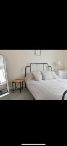 een slaapkamer met een bed met een spiegel en een tafel bij Southsea Home Stay : 2 Bedroom House with Garden and Hot Tub in Portsmouth