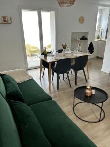 een woonkamer met een groene bank en een tafel bij La terrasse : Appartement chic 2 chambres au coeur de Pau in Pau