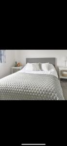 een bed met een wit dekbed in een slaapkamer bij Southsea Home Stay : 2 Bedroom House with Garden and Hot Tub in Portsmouth