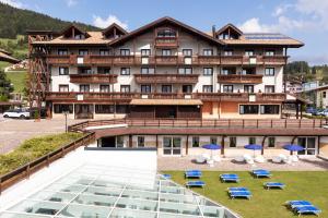 a large building with umbrellas in front of it at Golf Hotel in Folgaria