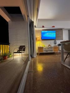 a living room with a large tv on a wall at Mendoza908 in Nueve de Julio