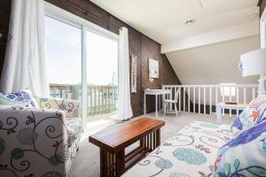 ein Wohnzimmer mit einer Couch und einem Tisch in der Unterkunft Oceanside Cottage -3BDR 2BA-Walk to Beach! in Kill Devil Hills