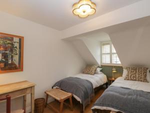 Habitación con 2 camas, mesa y ventana en Kyte Cottage en Shipston on Stour