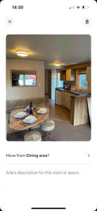 sala de estar con mesa y sillas y cocina en AJ’s Caravan Hire en Aberystwyth