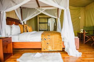 a bedroom with a bed with a canopy at Wigot Gardens Hotel in Kisumu