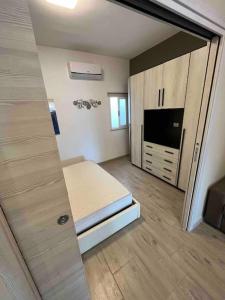 a room with a bed and a tv and a mirror at Appartamento vista mare in Agnone Bagni