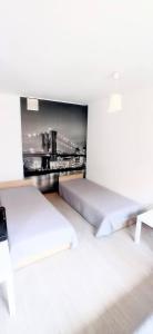 two beds in a room with a wall mural at Apartament Studio - Mehoffera 1 in Zabrze