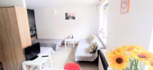 a small living room with a couch and a tv at Apartament Studio - Mehoffera 1 in Zabrze