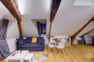 ein Wohnzimmer mit einem blauen Sofa und einem Tisch in der Unterkunft L'Azur / 100m Gare in Tours + 10 Fotos