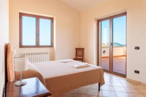 een slaapkamer met een bed en een tafel met een lamp bij Beautiful villa with swimming pool Italy in Itri