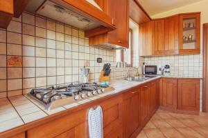 een keuken met houten kasten en een kookplaat bij Beautiful villa with swimming pool Italy in Itri