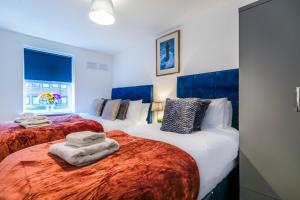 2 camas con toallas en un dormitorio en InSpires House Contractors, families, Wifi, Free Parking Town Centre, en Hemel Hempstead