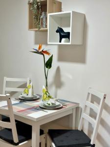 een tafel met twee stoelen en een vaas met een bloem bij Ferienwohnungen GoJa in Bad Königshofen im Grabfeld