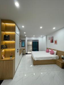 a bedroom with a large bed with pink pillows at Dodo home AC in Hanoi