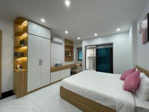 a bedroom with a white bed and a kitchen at Dodo home AC in Hanoi