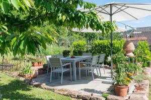 a table and chairs under an umbrella in a garden at Fewo Odenwald - Marie in Breuberg
