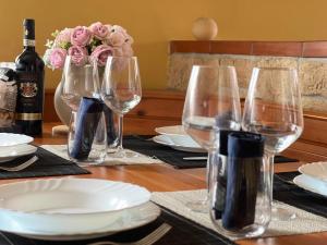 un tavolo con bicchieri da vino e un vaso con rose rosa di Skyscraper Apartment Pontedera a Pontedera