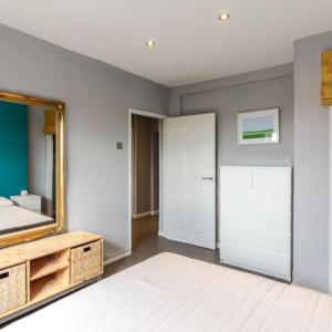- une chambre avec un miroir et un lit dans l'établissement Top Floor 1 Bedroom Apartment with views over London, à Londres