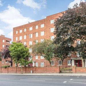 a brick building with trees in front of a street at Top Floor 1 Bedroom Apartment with views over London in London