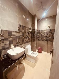 La salle de bains est pourvue de toilettes blanches et d'un lavabo. dans l'établissement The Solitaire Express Vrindavan, à Vrindavan