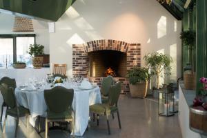 a dining room with a table and a fireplace at Kronen Gaard Hotel in Sandnes