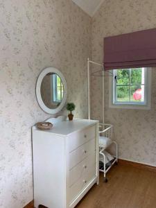 um quarto com uma cómoda branca e um espelho em The Open Hills em Chongsadao