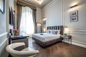 a bedroom with a bed and a chair and a window at Il Rivalta - Place of Charme in Florence