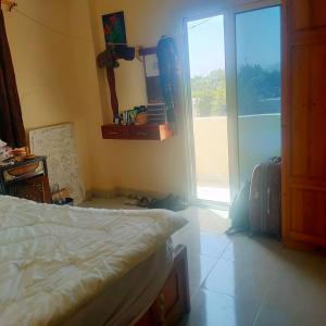 Un dormitorio con una cama y una puerta corrediza de vidrio. en Sina market, en Dahab