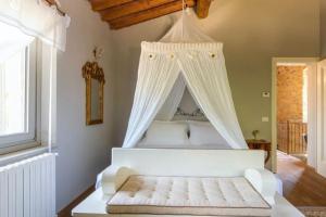 1 dormitorio con 1 cama blanca con dosel en Villa mulino del 500, en Carmignano