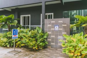 un edificio con un cartello davanti ad alcune piante di Groundfloor Poolside Manhattan Ipoh Free Netflix&Carpark a Ipoh