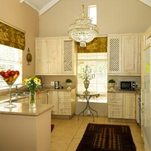 a kitchen with white cabinets and a chandelier at Country Retreat in Magaliesburg in Magaliesburg