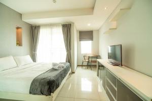 une chambre d'hôtel avec un lit et une télévision dans l'établissement Stylish & Cozy Studio in central Jakarta, SCBD, à Jakarta