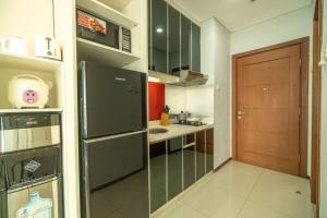 a kitchen with a black refrigerator and a sink at Stylish & Cozy Studio in central Jakarta, SCBD in Jakarta