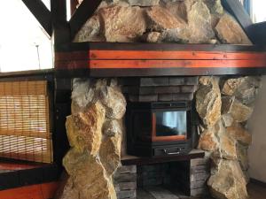 una chimenea de piedra con TV. en Hotel Barbizon, en Nyíregyháza