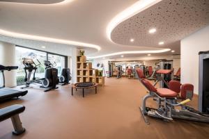 a gym with cardio equipment and chairs in a room at Hotel Chalet Das Alpenschlössel in Saltusio