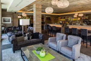 a lobby with chairs and a bar in the background at Hotel Chalet Das Alpenschlössel in Saltusio